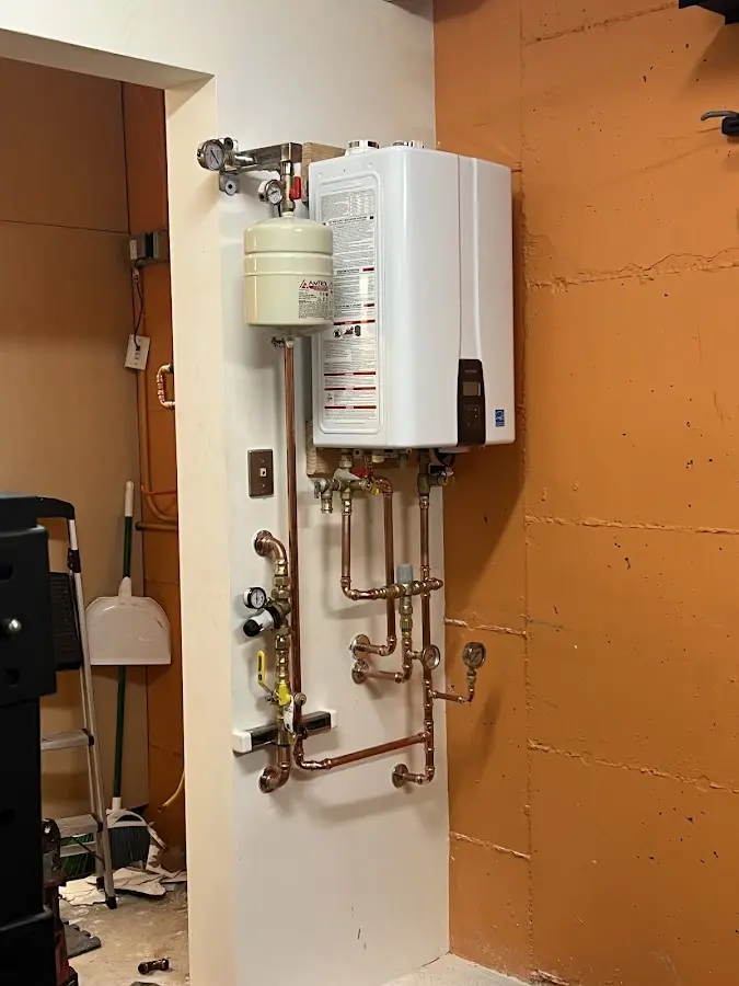 Plumbing technician inspecting water heater connections in Huntsville